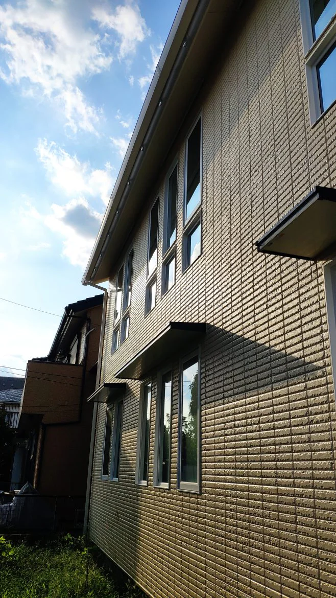 2階の窓は段窓風の既成品サイズの窓の組み合わせ